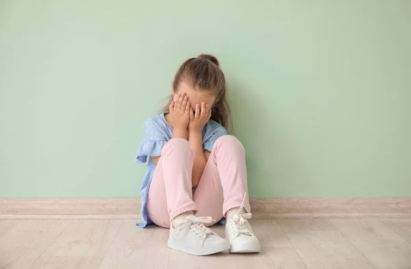 Niña Triste Con Trastorno Autista Sentada Cerca Pared Color — Foto de Stock