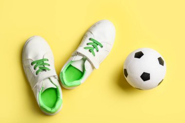 Futbol topu ve renkli arka planda ayakkabılar