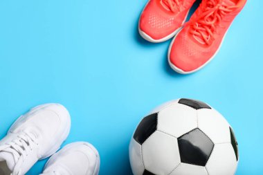 Futbol topu ve renkli arka planda ayakkabılar