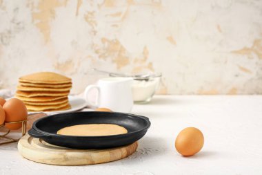 Kızartma tavası ve lezzetli krep masada.