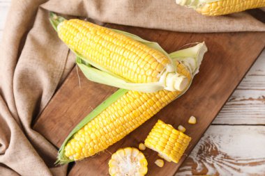 Masasında taze mısır koçanı olan bir tahta.