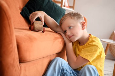 Otistik bozukluğu olan küçük çocuk evde oyuncaklarla oynuyor.