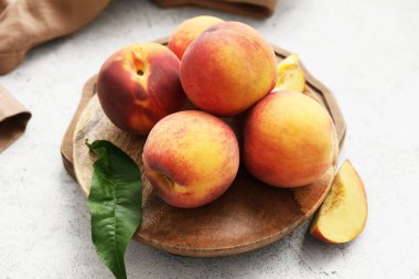 Beyaz arka planda olgun şeftalili tabak