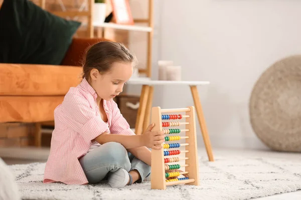 Little girl with autistic disorder playing with abacus at home