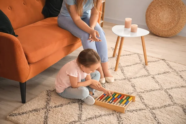 Little girl with autistic disorder playing with abacus at home