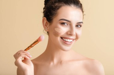 Yüzünde temeli olan güzel, genç bir kadın.