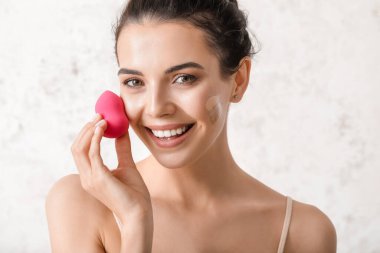 Yüzünde temeli parlak arka planda olan güzel genç bir kadın.