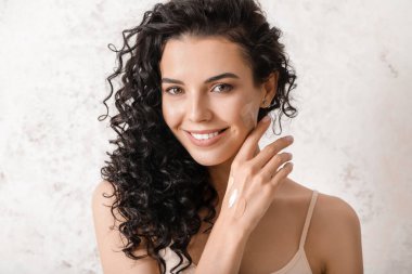 Yüzünde temeli parlak arka planda olan güzel genç bir kadın.