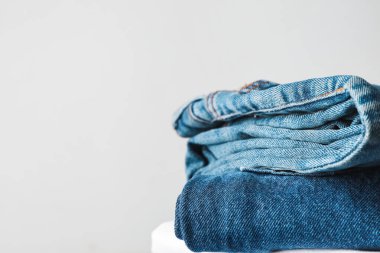 Açık arkaplanda kot pantolon yığını