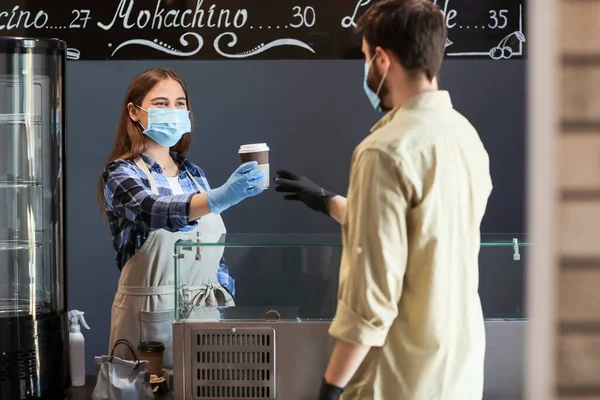 Female barista with client in modern cafe. Concept of epidemic