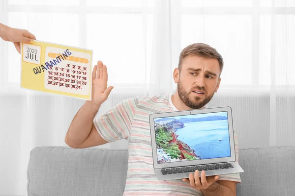 Troubled man with calendar and laptop dreaming about vacation during quarantine at home