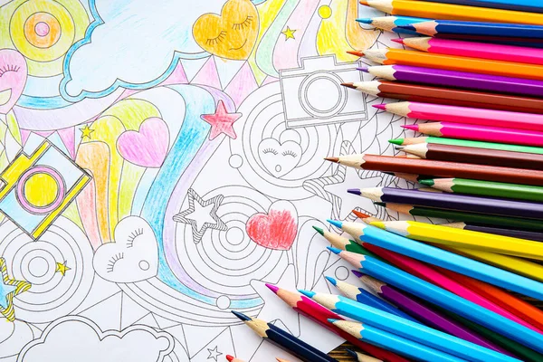 Coloring picture and pencils on table