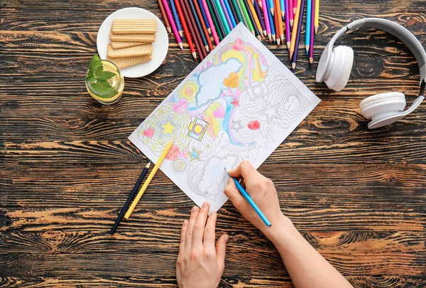 Woman coloring picture at table