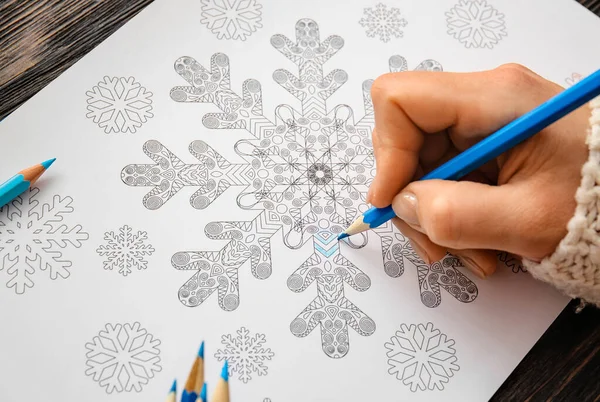 Woman coloring picture at table, closeup