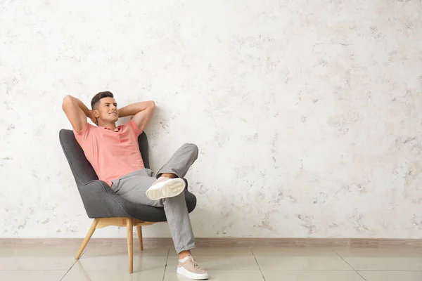 Hombre Joven Relajándose Sillón Cerca Pared Luz — Foto de Stock