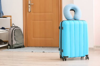 Odada yastık ve bavul var.