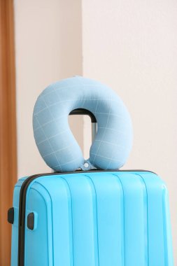 Odada yastık ve bavul var.