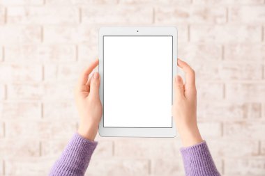 Tuğla zemin üzerinde modern tablet bilgisayarı olan eller