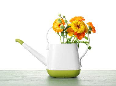 Beyaz arka planda çiçekler olan teneke kutu sulama