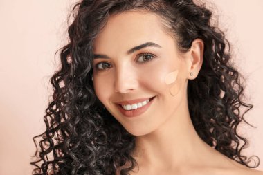 Yüzünde temeli olan güzel, genç bir kadın.