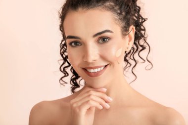 Yüzünde temeli olan güzel, genç bir kadın.