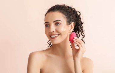 Yüzünde temeli olan güzel, genç bir kadın.