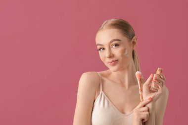 Yüzünde temeli olan güzel, genç bir kadın.