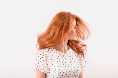 Açık arkaplanda güzel kızıl saçlı bir kadın.