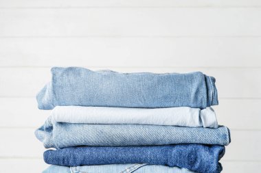 Beyaz arka planda kot pantolon yığını