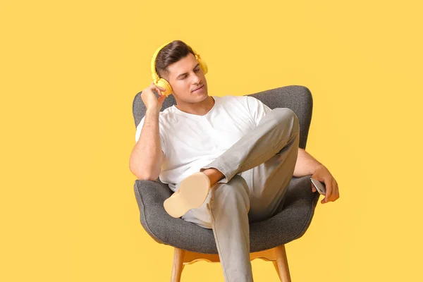 Young Man Listening Music While Relaxing Armchair Color Background — Stock Photo, Image