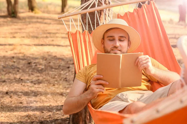 Jongeman Met Boek Ontspannen Hangmat Buiten — Stockfoto