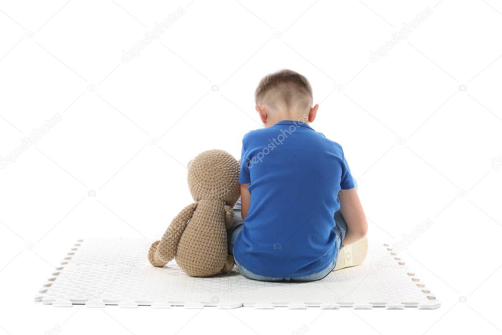 Sad little boy with autistic disorder on white background, back view