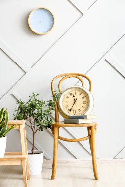Ev bitkileri ve saatlerle dolu bir odanın içinde.