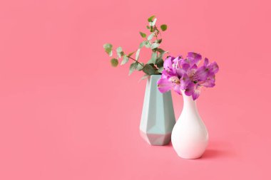 Renkli arka planda çiçekli güzel vazolar