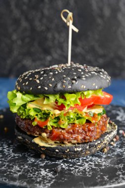 Lezzetli hamburger ve siyah çörek, yakın plan.