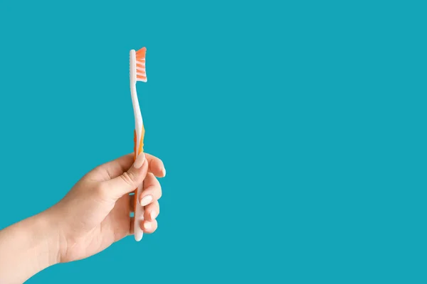 Mano Con Cepillo Dientes Sobre Fondo Color — Foto de Stock