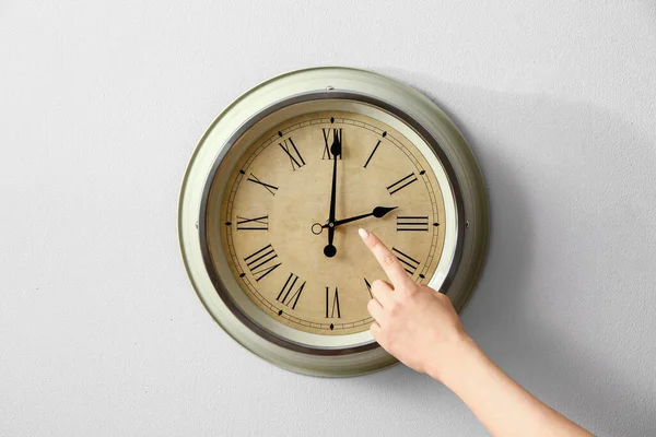 Duvarda saate dokunan kadın