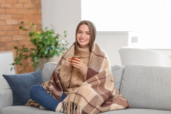 Güzel genç bayan evde çay içiyor.