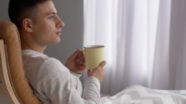 Evde çay içen yakışıklı genç adam.