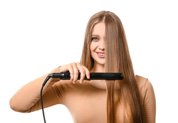 白い背景に髪のための平坦化鉄を使用して美しい若い女性 — ストック写真