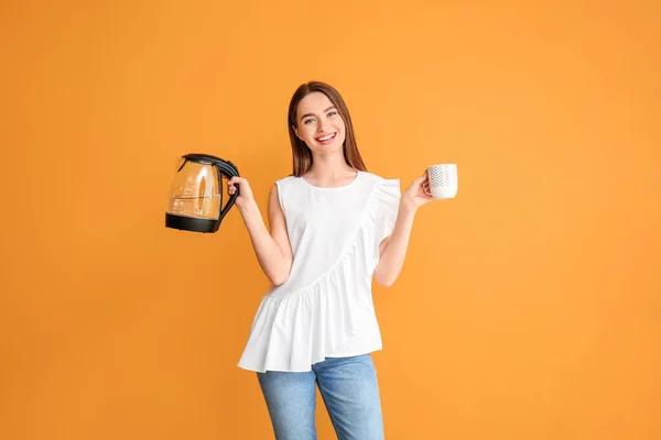 Junge Frau Mit Wasserkocher Und Tasse Auf Farbigem Hintergrund — Stockfoto