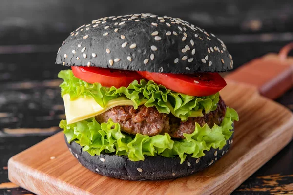Smaczny Burger Czarną Bułką Stole Zbliżenie — Zdjęcie stockowe