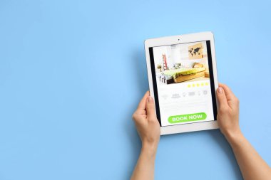 Renkli arka planda tablet bilgisayarı olan eller. Çevrimiçi rezervasyon kavramı