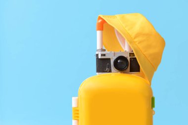 Fotoğraf makinesi ve şapka arkaplan renginde çocuk bavulu.