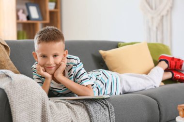 Evde kitap okuyan şirin bir çocuk.