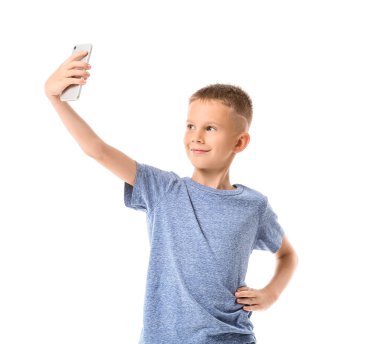 Beyaz arka planda selfie çeken sevimli küçük çocuk.