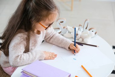 Evde çizim yapan küçük tatlı bir kız.