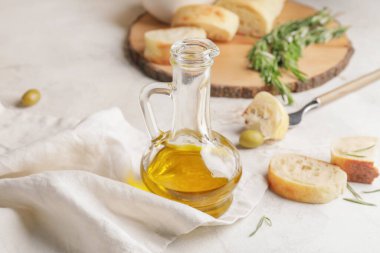 Beyaz arka planda bir şişe lezzetli zeytinyağı ve ekmek.