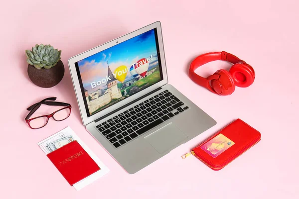 Modern laptop and travel accessories on color background. Concept of online booking