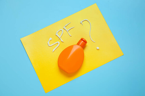 Бутылка солнцезащитного крема на цветном фоне